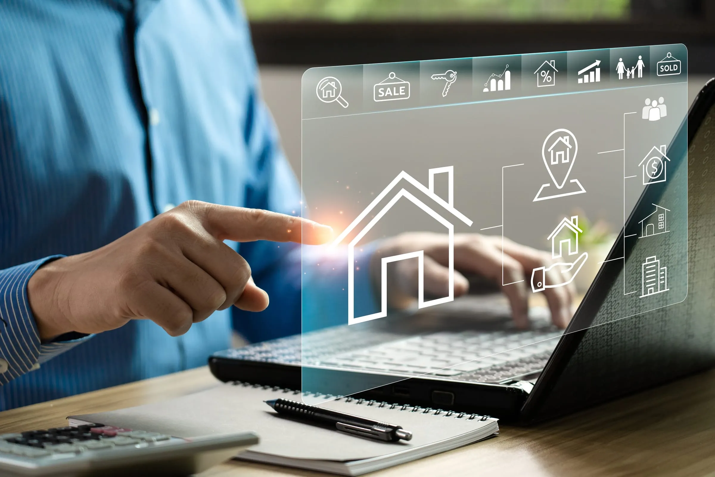 Hand wijst op een laptop naar een digitaal overzicht van een woning